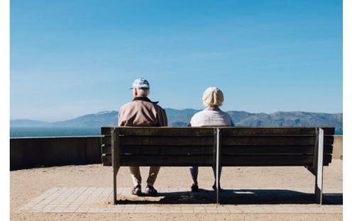 Zwei Senioren sitzen auf einer Parkbank